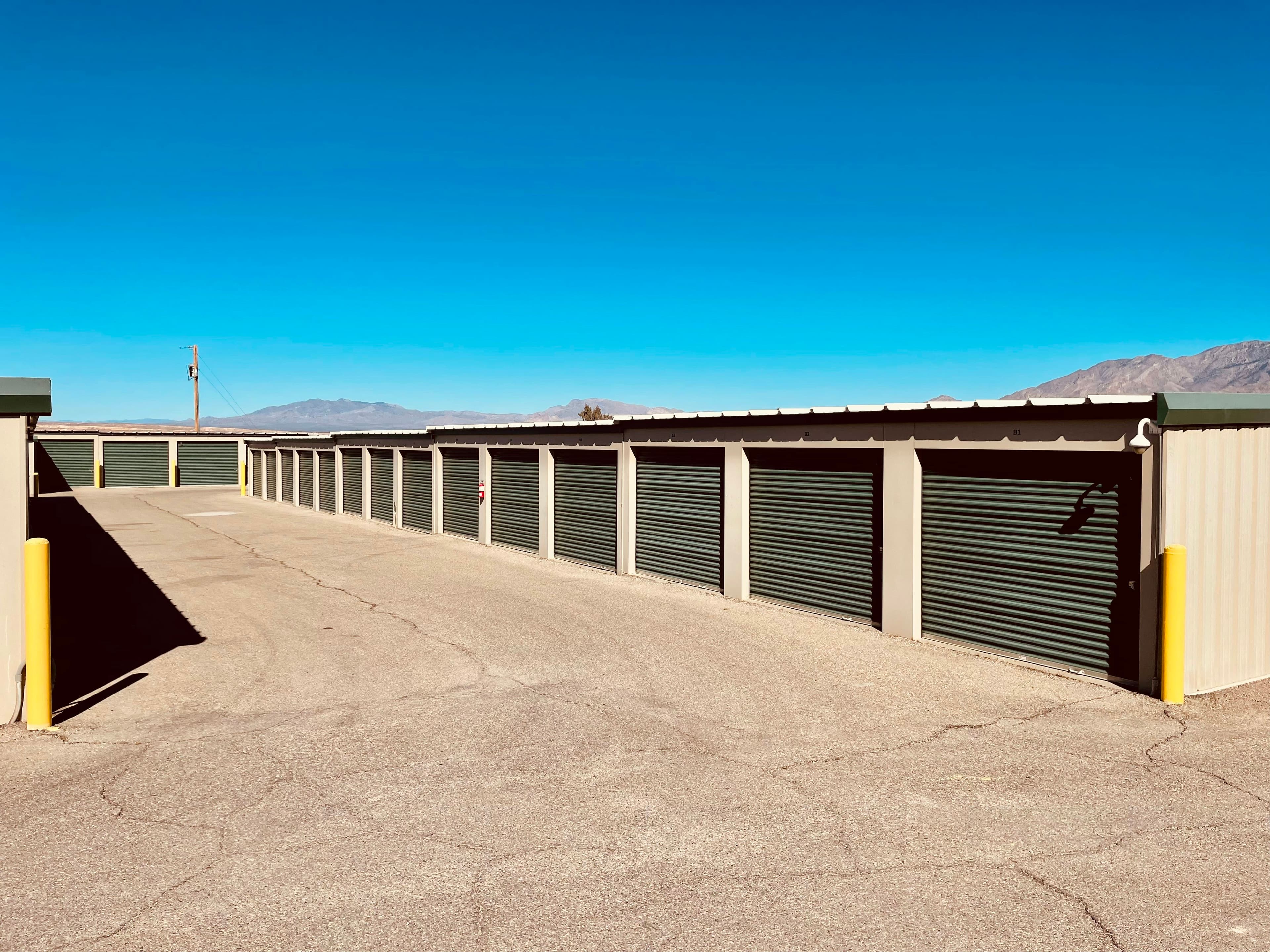 A row of drive-up storage units with roll-up doors