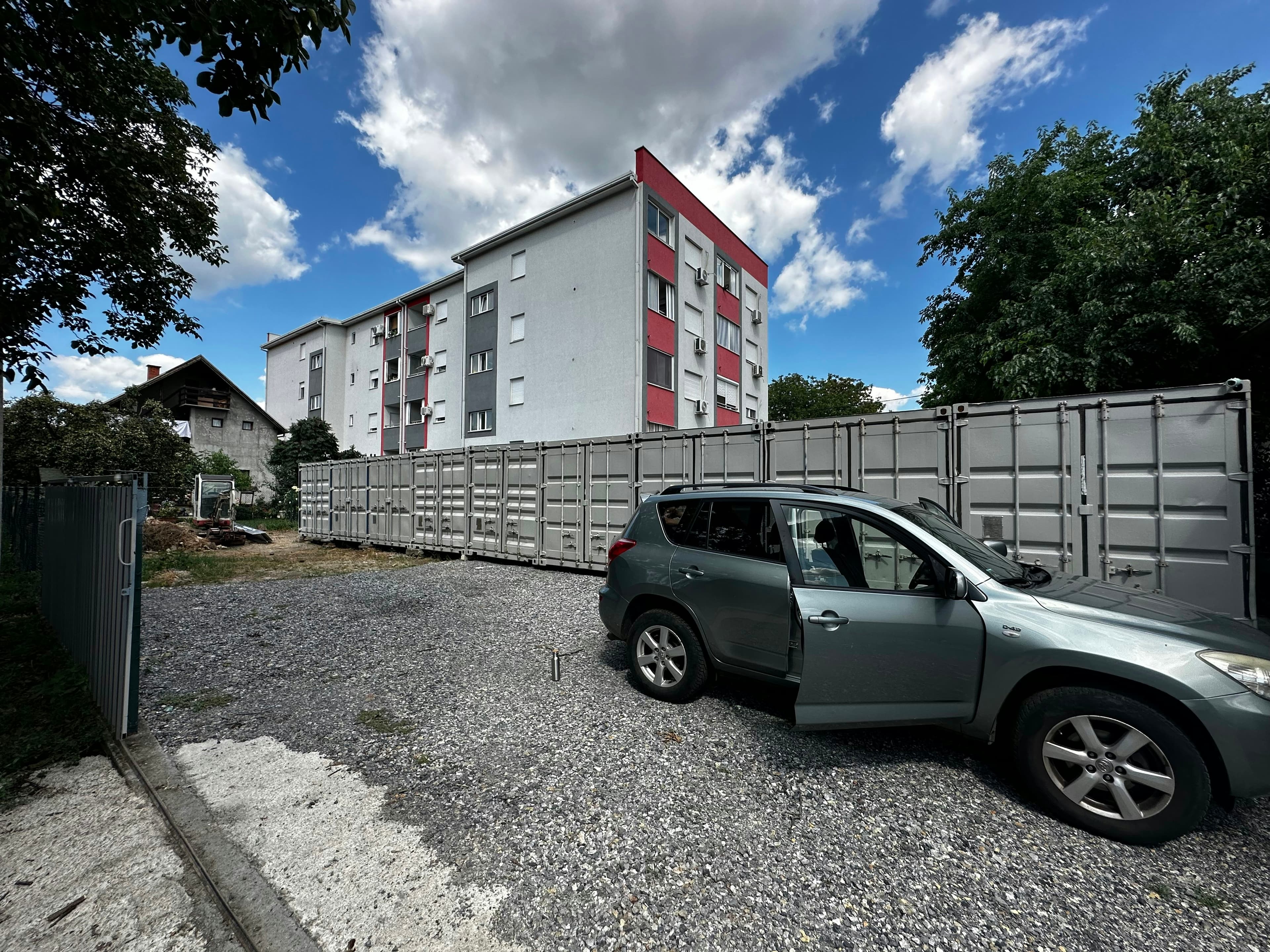 A car parked in front of a row of storage units